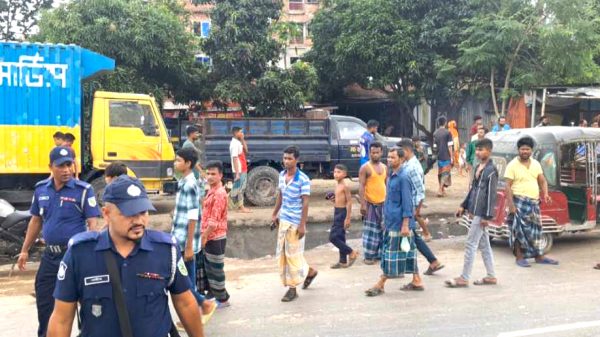 গাজীপুরে দুর্ঘটনার পর উদ্ধারকাজ চালানো হচ্ছে, পাশে পড়ে আছে মোটরসাইকেল ও কাভার্ড ভ্যান।
