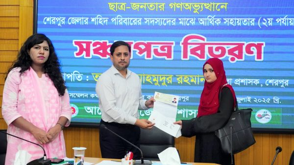 শেরপুর জেলা প্রশাসনের সম্মেলন কক্ষে জুলাই গণঅভ্যুত্থানে শহিদ পরিবারের মাঝে সঞ্চয়পত্র বিতরণ অনুষ্ঠানের ছবি।