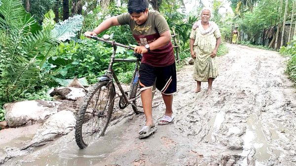 রাজশাহীর পুঠিয়ায় ধোপাপাড়ার কাঁচা রাস্তায় হাঁটু কাদা ভেদ করে হেঁটে যাচ্ছেন শিক্ষার্থীরা ও পথচারীরা।