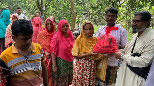 বাঘায় পানিবন্দি মানুষের মাঝে খাদ্যসামগ্রী বিতরণ করছেন মানবিক মিঠুর পিতা হামিদুল ইসলাম।