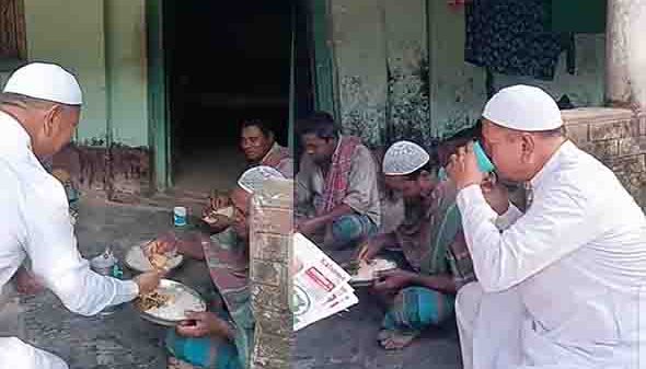 নান্দাইলের কুতুবপুরে গণসংযোগে আনোয়ারুল ইসলাম চান স্থানীয়দের সঙ্গে কথা বলছেন এবং খাবার ভাগ করে নিচ্ছেন।