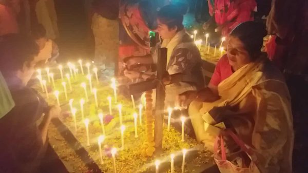 জয়পুরহাটের পাঁচবিবিতে পাথরঘাটা ক্যাথলিক মিশনের কবরস্থানে প্রিয়জনের কবরের পাশে মোমবাতি জ্বালিয়ে প্রার্থনা করছেন স্বজনেরা