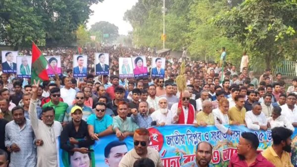 বাঘা শহরে জাতীয় বিপ্লব ও সংহতি দিবস উপলক্ষে বের হওয়া বর্ণাঢ্য র‍্যালি, পথে সমর্থকরা ব্যানার ও স্লোগানসহ অংশগ্রহণ করছেন।